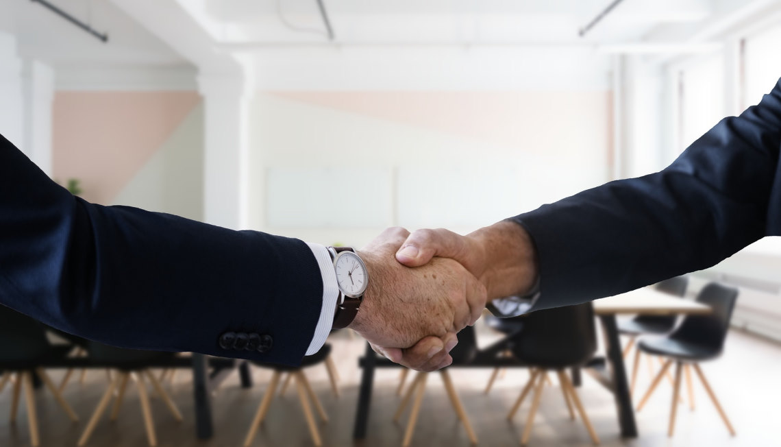 shaking hands in boardroom