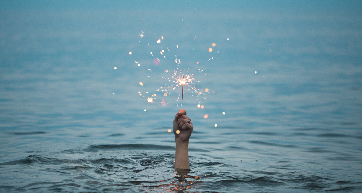 Hand coming out of water holding sparkler