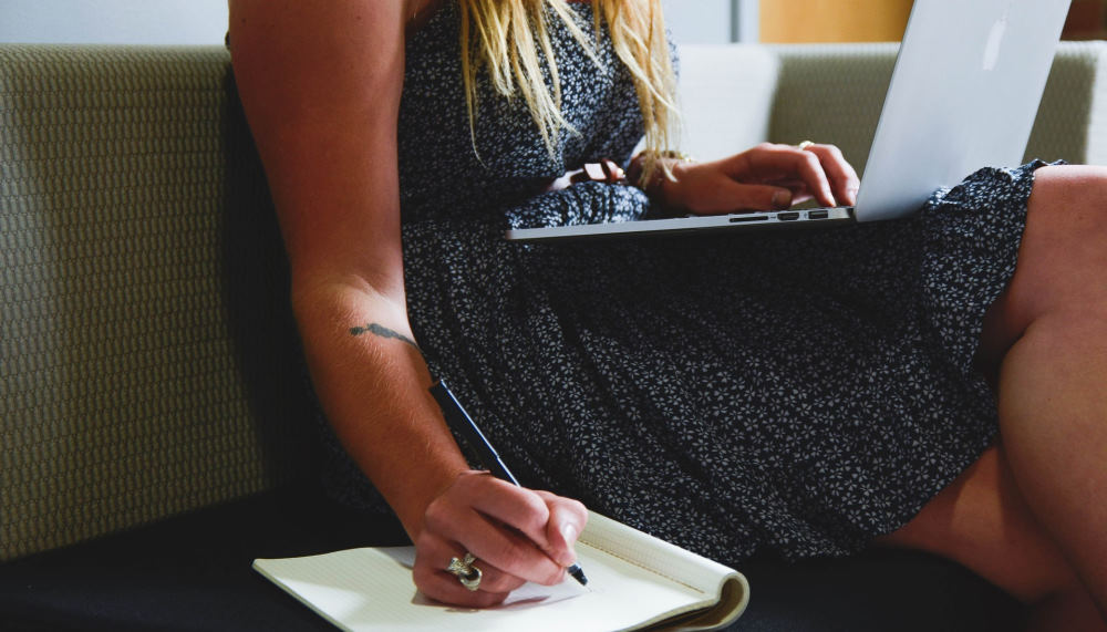 Woman writing in notepad.