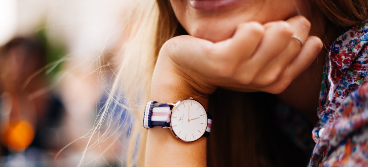 Woman resting chin on hand wearing watch